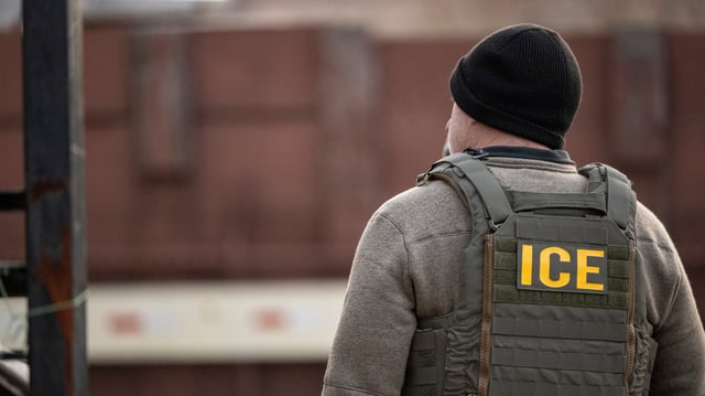 File Photo: A unidentified person wears a vest reading the words ICE.