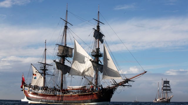 A replica of Captain Cook’s ship, HMS Endeavour, arrives in Sydney harbour. The location of the real thing has been located after years of searching and discussion
