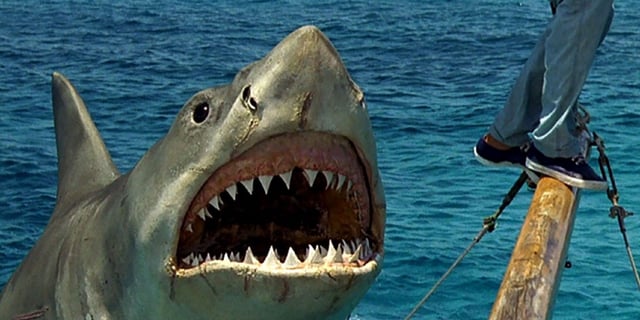 A great white shark opens his mouth to eat a man on a boat in Jaws: The Revenge