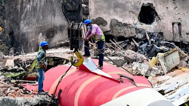 The wreckage of the crashed Air India plane being lifted by a crane from the roof of the BJ Medical College mess building. (HT PHOTO)