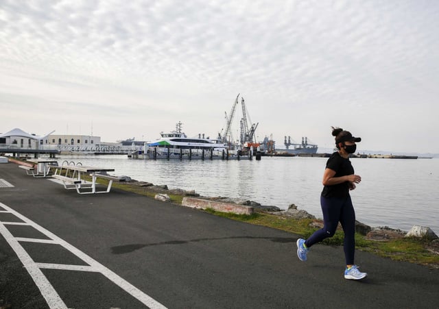 A woman runs along bay trail at the former naval station at Alameda Point in 2022. An entrepreneur is pushing a plan to turn the area into “Silicon Valley 2.0.”