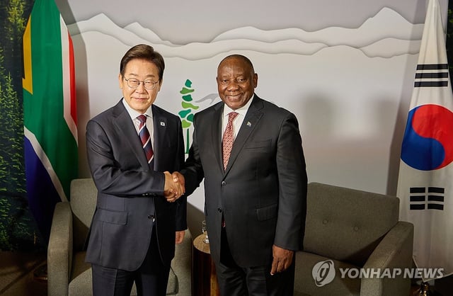 President Lee Jae-myung (L) shakes hands with South African President Cyril Ramaphosa during their meeting in Calgary, Canada, on June 16, 2025, on the sidelines of the Group of Seven summit. (Pool photo) (Yonhap)