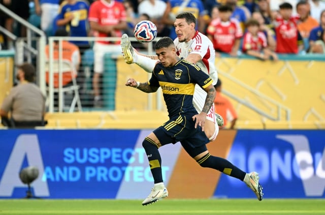 Le défenseur argentin du Boca Juniors Ayrton Costa (en bas) et l'attaquant italien du Benfica Andrea Belotti, le 16 juin 2025 à Miami pendant leur match de Mondial des clubs