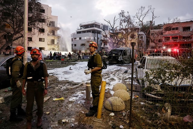 Emergency personnel work at an impact site following an Iranian missile attack on Israel, in Tel Aviv, June 16, 2025.