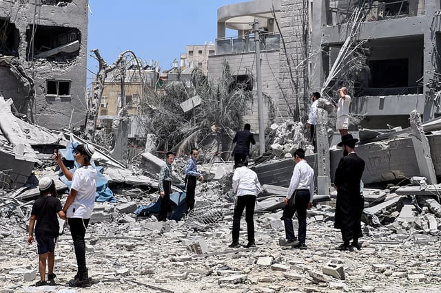 Ultra Orthodox jews look at an impacted site following missile attack from Iran on Israel, in Bnei Brak, Israel June 16, 2025.  REUTERS/Miro Maman/File Photo