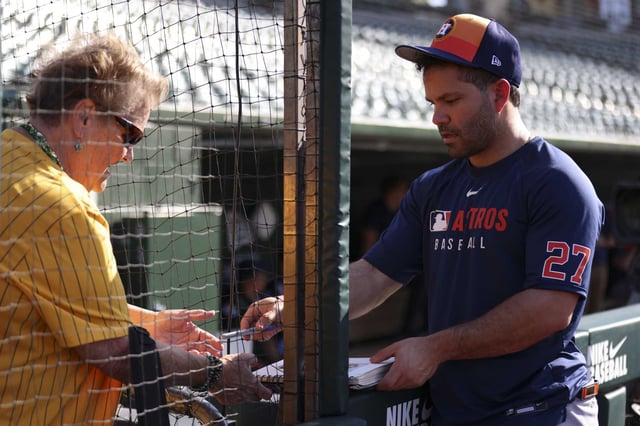 Houston Astros&#39; Jose Altuve, right, gives an autograph to a fan before a baseball game against the Athletics, Monday, June 16, 2025, in West Sacramento, Calif. (AP Photo/Scott Marshall)
