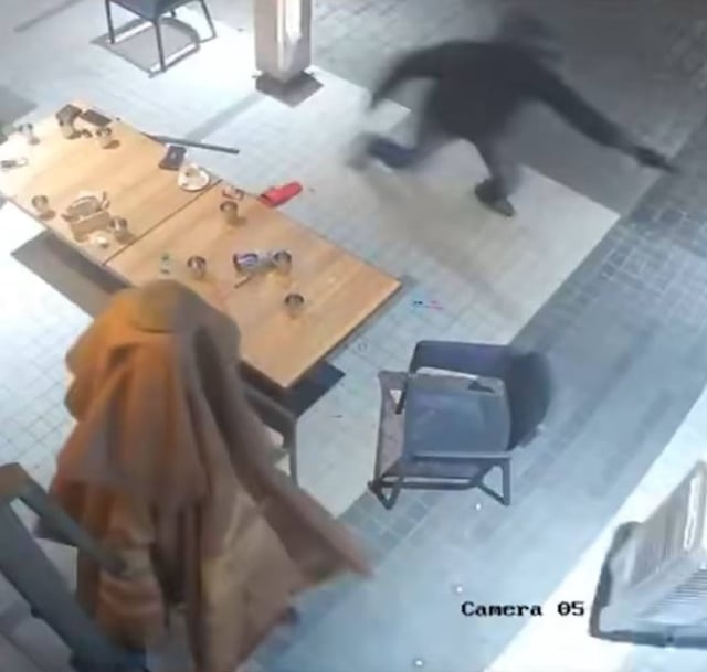 A helmeted gunman is caught on CCTV chasing his victim in a Brickfields restaurant. Photo: Handout