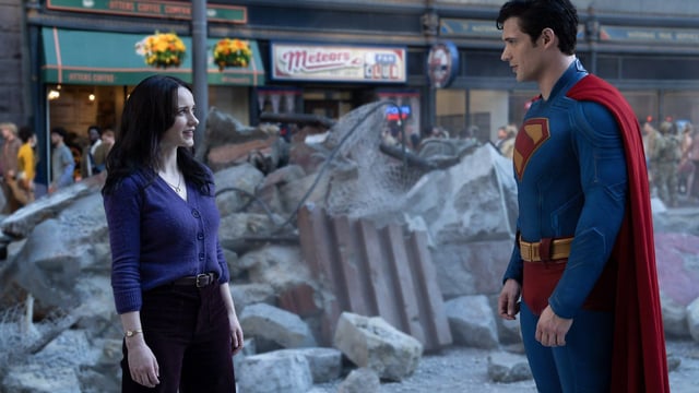 Lois Lane and Superman standing in crumbling Metropolis.