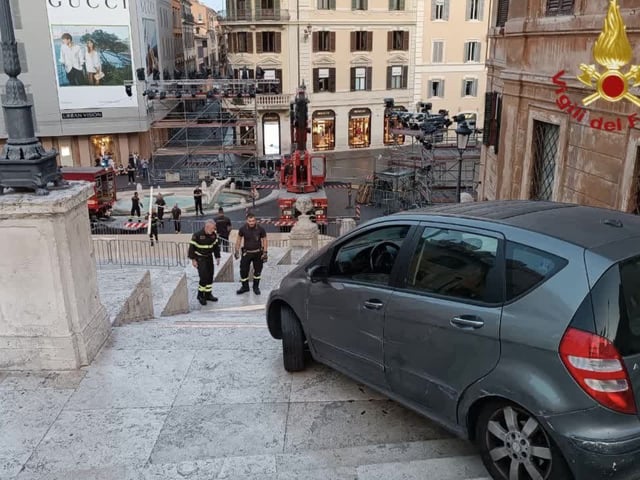 Mitglieder der Feuerwehr stehen vor dem Auto eines 80-Jährigen, das in der Nacht auf der Spanischen Treppe von der Polizei gestoppt worden ist. 