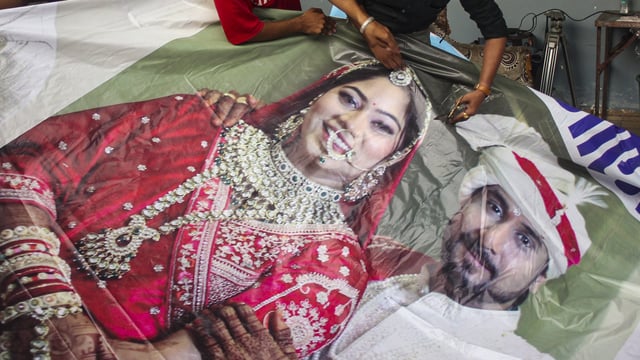 Raja Raghuvanshi's family members cutting out the picture of his wife Sonam Raghuvanshi from a poster of their marriage after she was accused of plotting Raja's murder in Meghalaya, in Indore,