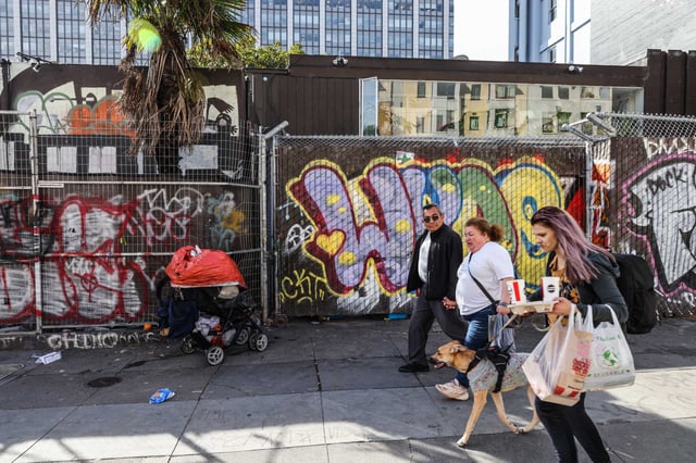 People pass by the Phoenix Hotel on Eddy Street in San Francisco in 2024.