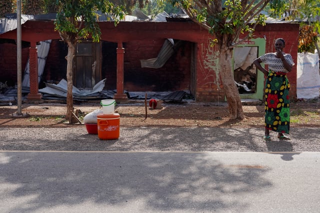 A woman stands in front of the remains of a burnt building following a deadly gunmen attack in Yelewata, Benue State, Nigeria, June 16, 2025. REUTERS/Marvellous Durowaiye