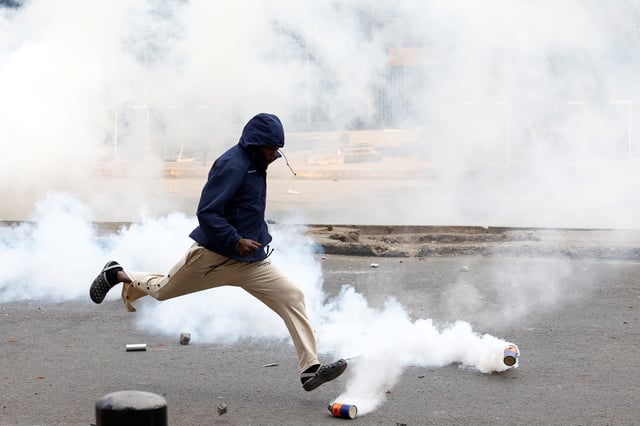 A protester runs to kick a tear gas canister during a demonstration over the death of Kenyan blogger Albert Ojwang in police custody, in downtown Nairobi, Kenya June 17, 2025. REUTERS/Thomas Mukoya REFILE - QUALITY REPEAT