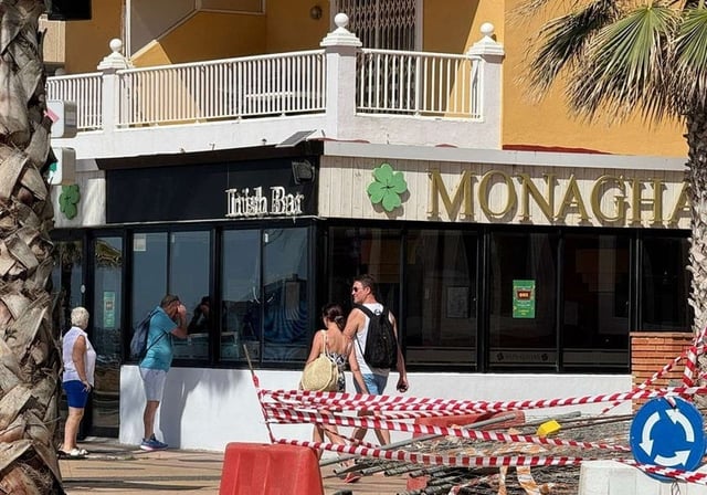 Un curioso mira dentro del bar en el que tuvo lugar el crimen