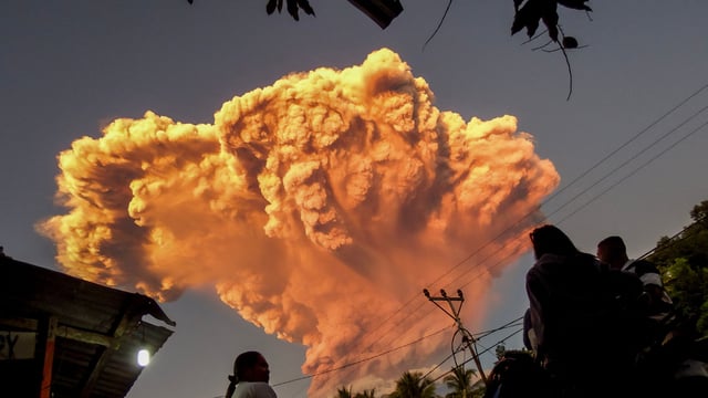 Villagers watch the eruption of Mount Lewotobi Laki-Laki as seen from Talibura village in Sikka, East Nusa Tenggara, on June 17