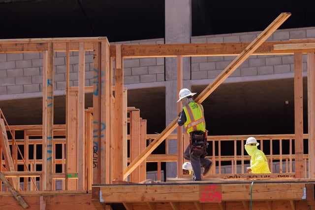 Construction employees work in a multifamily housing project in San Diego, California, U.S., September 19, 2023. REUTERS/Mike Blake/ File Photo
