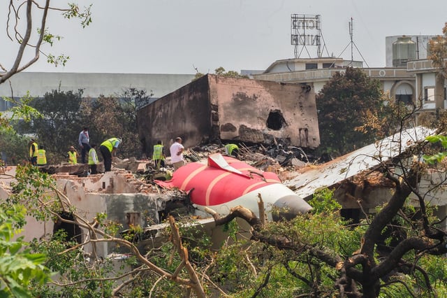 Une équipe d’enquête inspecte les débris du vol 171 d’Air India, le 13 juin 2025, un jour après son crash survenu 
dans une zone résidentielle près de l’aéroport, à Ahmedabad.