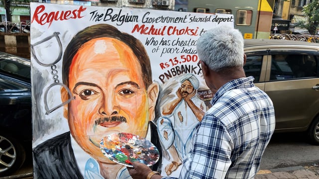 Teacher from Gurukul School of Art paints a poster requesting deportation of Mehul Choksi to India, in Mumbai
