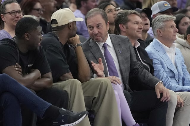 Golden State Warriors forward Jonathan Kuminga, left, talks with owner Joe Lacob during a WNBA basketball game between the Golden State Valkyries and the Los Angeles Sparks in San Francisco, Friday, May 16, 2025. (AP Photo/Jeff Chiu)