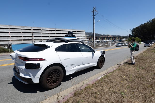 Reporter Ryan Macasero exits a Waymo taxi at the Colma BART station,Tuesday, Aug. 6, 2024, the first day the driverless taxi company extended service to the north peninsula cities of Daly City, Colma and Broadmoor. (Karl Mondon/ Bay Area News Group)
