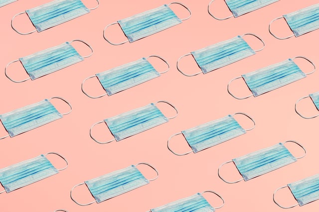 FILE: A group of masks laid in a pattern on a colored background. Health officials say a new subvariant of COVID nicknamed Nimbus is spreading in California.