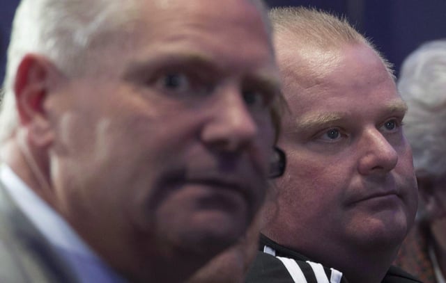 Former Toronto mayor Rob Ford, right, and his brother Doug attend a rally where Conservative leader Stephen Harper delivered a speech in Toronto on Saturday, Oct. 17, 2015. Doug Ford says medical tests have shown that a new tumour doctors discovered on the former Toronto mayor's bladder is cancerous