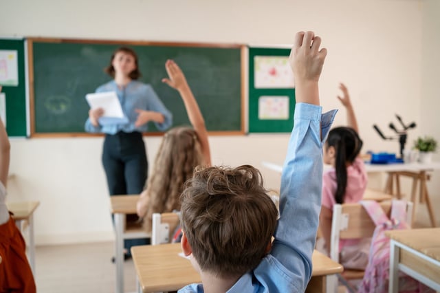 Caucasian young woman teacher teaching student in classroom at school. Attractive beautiful female instructor master explain and educate children with fun activity at preschool nursery kindergarten.