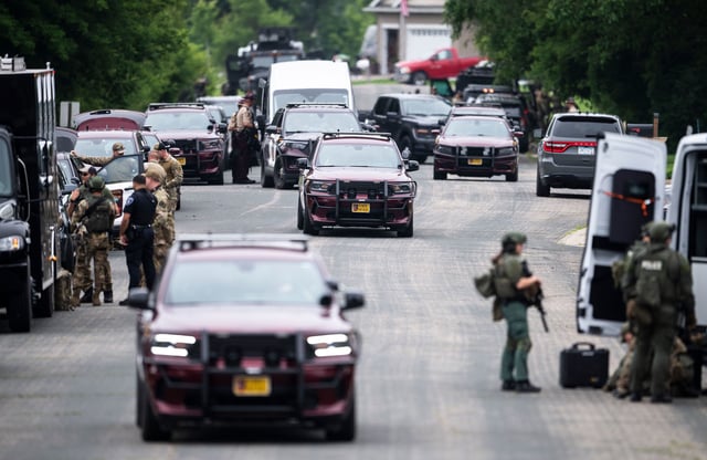 Law enforcement stage in a neighborhood on June 15, 2025, in Green Isle, Minnesota.