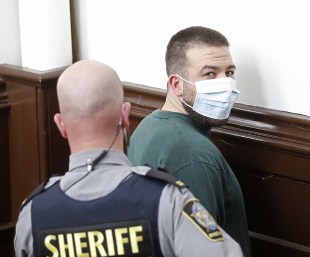  Adam Joseph Drake looks at the media as his hands are cuffed following his arraignment in Halifax provincial court Oct. 31, 2022, on a charge of first-degree murder in the November 2016 shooting death of Tyler Keizer.