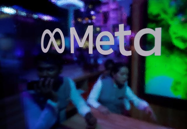 People are seen behind a logo of Meta Platforms, during a conference in Mumbai, India, September 20, 2023. REUTERS/Francis Mascarenhas/File Photo