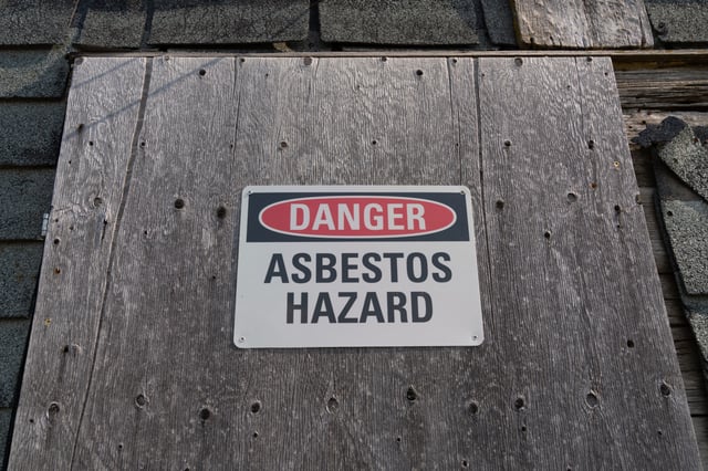 Sign warning of the presence of cancer causing asbestos in an old building
