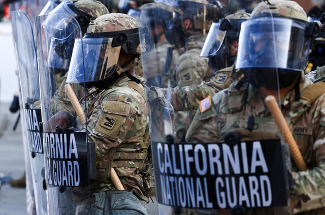 National Guard troops wear gas masks during protests against federal immigration sweeps, in Los Angeles on June 12.