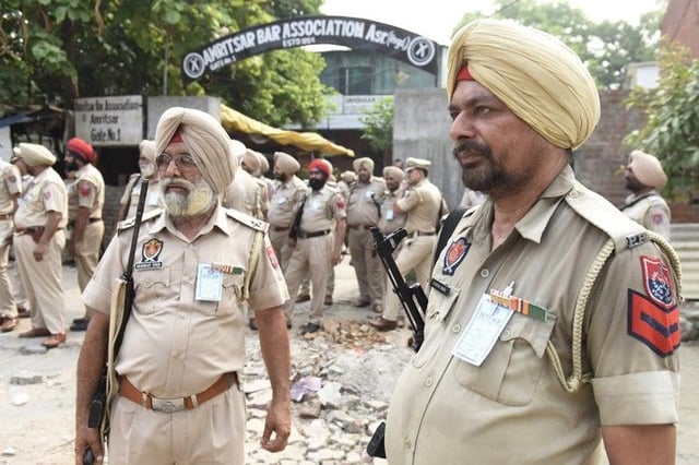 Police stand guard outside a court after Lawrence Bishnoi was brought in in relation to the killing of Rana Kandowalia, in Amritsar on June 28, 2022. India's notorious Bishnoi crime gang has a grim reputation for assassination and extortion on home soil, but now stands accused of involvement in the murder of Sikh separatist in Canada. (Photo by Narinder NANU / AFP)