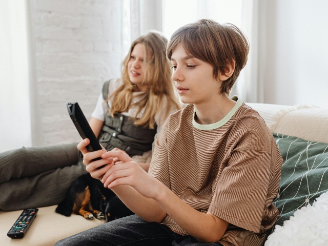 A Boy Holding a TV Remote