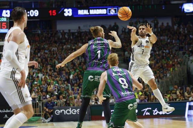 El base argentino del Real Madrid Facundo Campazzo (d) efectúa un pase ante el Unicaja.