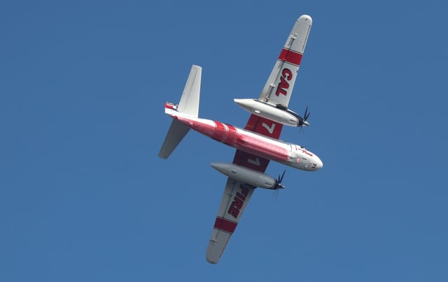 A Cal Fire tanker makes a pass over a brushfire in the hills above San Marcos and Carlsbad on Thursday, June 12, 2025. (Hayne Palmour IV / For The San Diego Union-Tribune)