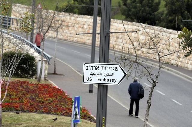 A man walks next to a road sign directing to the U.S. embassy in Jerusalem, February 18, 2019. Picture taken February 18, 2019 REUTERS/Ammar Awad/File Photo