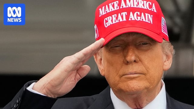 Trump salutes while wearing red MAGA hat