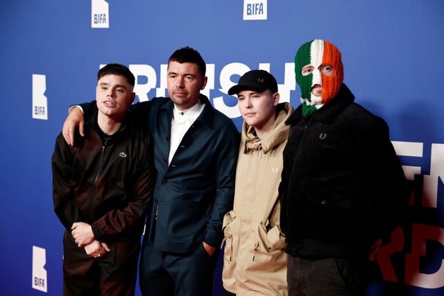 Le réalisateur Rich Peppiatt (2e G) pose avec les membres du trio de rap nord-irlandais Kneecap Moglai Bap (gauche), Mo Chara (2e droite) et DJ Provai (droite) sur le tapis rouge des British Independent Film Awards (BIFAs) à Londres le 8 décembre 2024