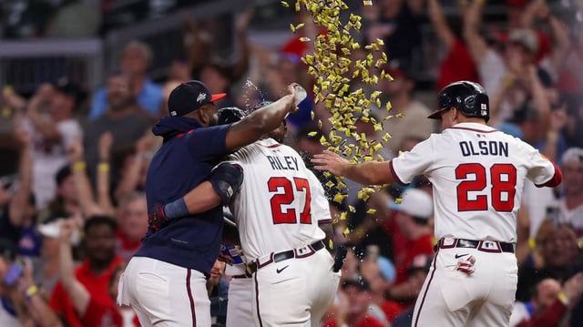 Braves third baseman Austin Riley (27) celebrates with teammates after driving in the winning run in a 5-4 victory over the Mets on Tuesday.