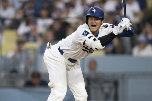 Los Angeles Dodgers' Shohei Ohtani takes a hit by pitch during the third inning of a baseball game against the San Diego Padres in Los Angeles, Tuesday, June 17, 2025. (AP Photo/Kyusung Gong)