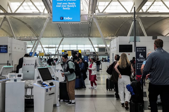 Travellers are seen in the Delta Airlines check-in area at John F. Kennedy International Airport (JFK) in New York City, U.S., May 7, 2025. REUTERS/Jeenah Moon/File Photo