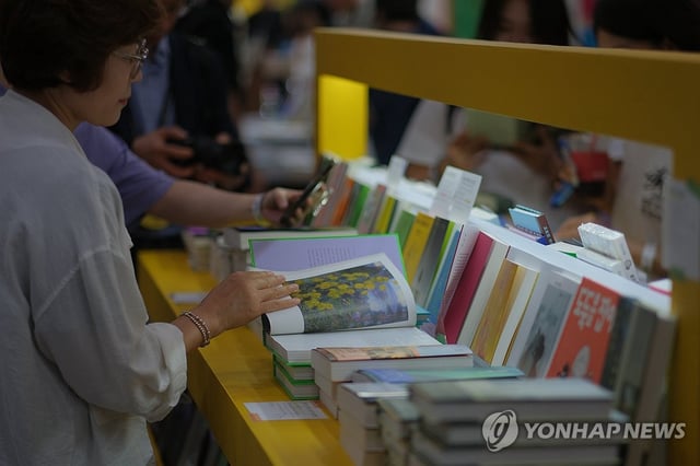 A visitor reads a book at the Seoul International Book Fair, held at the COEX exhibition hall in Seoul on June 18, 2025. (Yonhap) 
