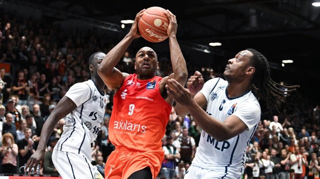 Chemnitz's DeAndre Lansdowne (M) setzt sich gegen Heidelbergs Spieler Bakary Dibba (l) und DJ Horne durch.