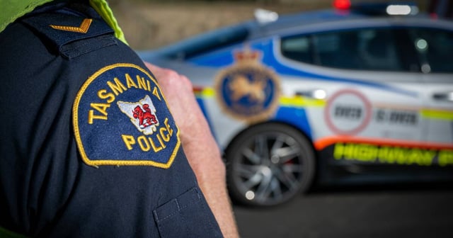 Police officer standing near patrol car. File picture by Paul Scambler.