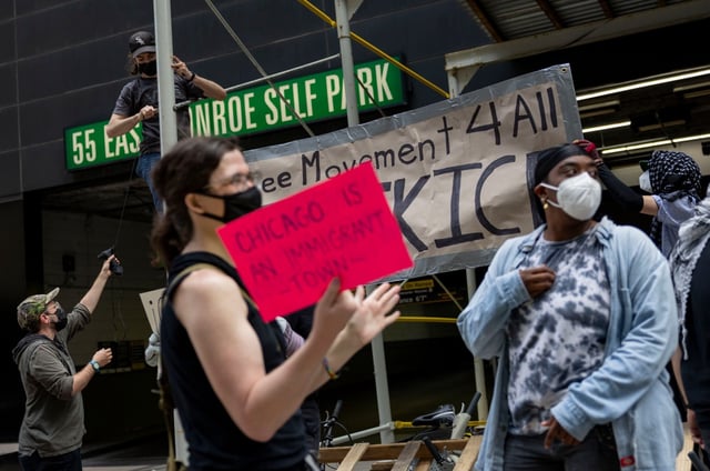 Protesters hang a banner and blockade a vehicle entrance to immigration court at 55 E. Monroe St. in the Loop on June 17, 2025. (Brian Cassella/Chicago Tribune)