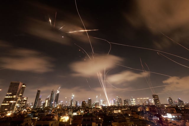 TOPSHOT - Israeli air defence systems are activated to intercept Iranian missiles over the Israeli city of Tel Aviv early on June 18, 2025. Israel and Iran exchanged fire again on June 17, the fifth day of strikes in their most intense confrontation in history, fuelling fears of a drawn-out conflict that could engulf the Middle East. (Photo by Menahem Kahana / AFP) (Photo by MENAHEM KAHANA/AFP via Getty Images)          