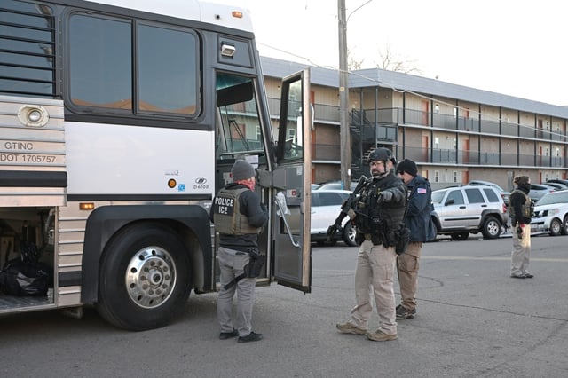 A bus is parked outside as federal law enforcement officers conduct an immigration enforcement operation at the Cedar Run Apartments on South Oneida Steet in Denver on Wednesday, Feb. 5, 2025. ICE raids were conducted at multiple apartment buildings across the metro area. (Photo by Hyoung Chang/The Denver Post)