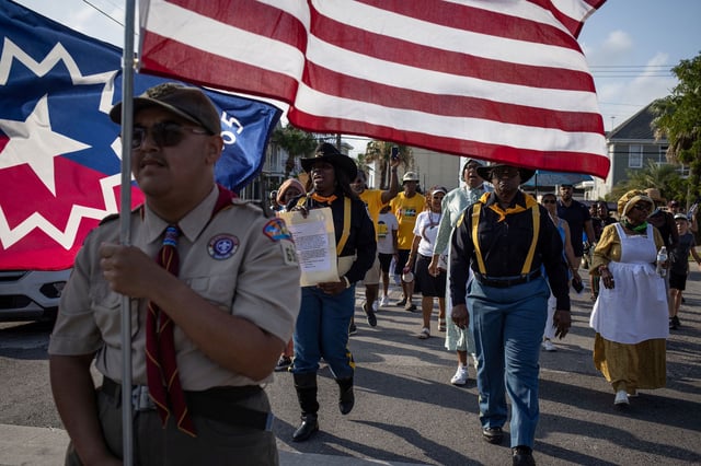 Trooper Jackie Quinn, representing "Buffalo Soldiers" of the 9th and 10th Cavalry, carries the General Order No. 3 during a march reenactment in celebration of Juneteenth in Galveston, Texas, U.S., June 19, 2023. REUTERS/Adrees Latif
