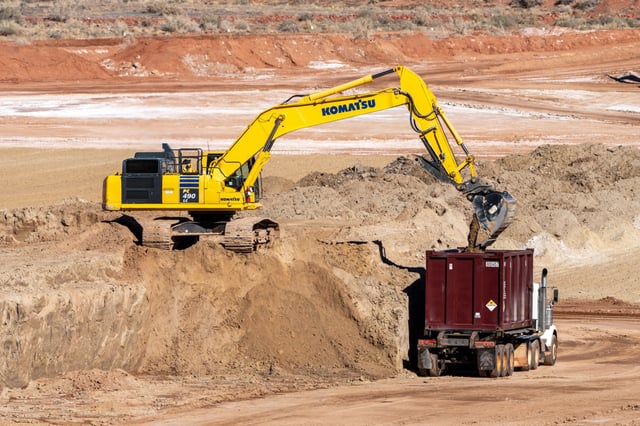 A heavy duty excavator loads a container truck with hazardous uranium tailings at the UMTRA remediation project in Moab, Utah, on Feb. 9, 2023.